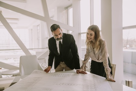 Business people looking at plans in the modern office