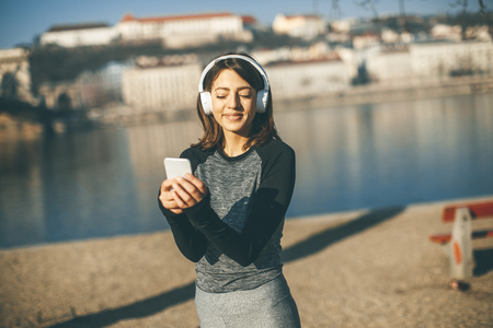 Young athlete woman with mobile phone on the bridhe in Budapest, Hungaryの写真素材