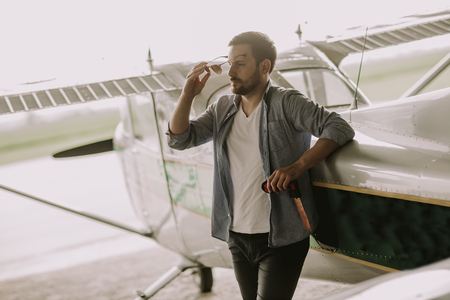 Handsome young pilot checking ultralight airplane before flightの写真素材