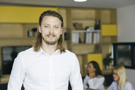 Confident young business man standing in the officeの写真素材