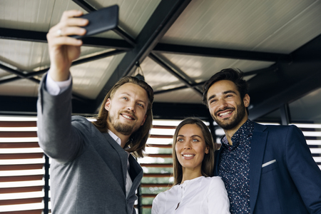 Portrait of smiling business people posing for selfieの写真素材