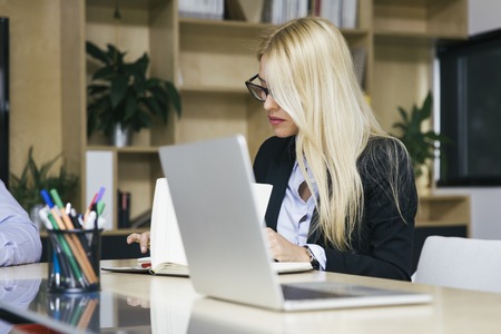 Portrait of attractive blond businesswoman working in modern office