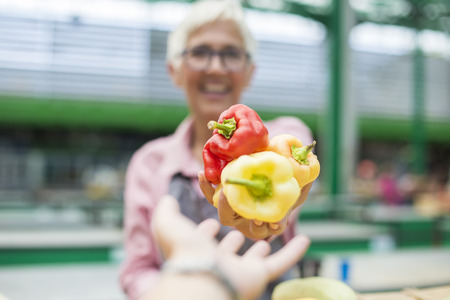 Portrait of senior woman sells organic vegetable on marketの写真素材