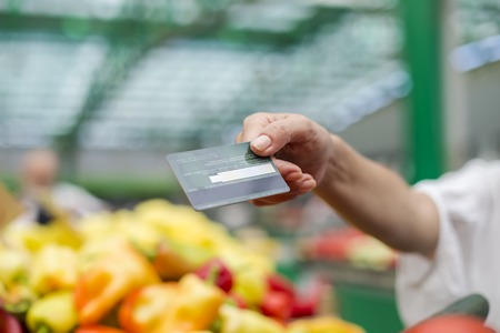 Close up view at woman pays with credit card at a marketの写真素材