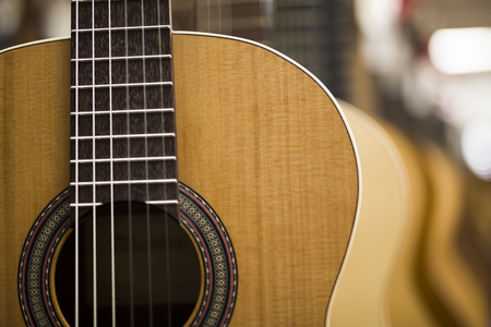 Close up view at acoustic guitars in row in music shop