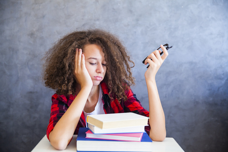 Portrait of curly hair teen girl above book restingの写真素材
