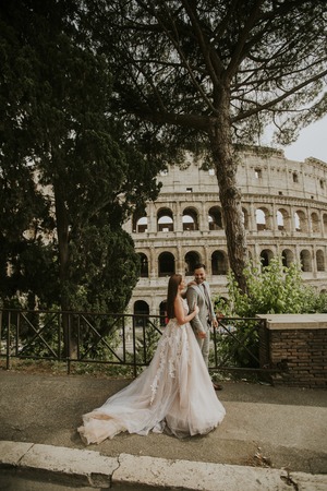 View at bride and groom wedding posing in front of Colosseum, Rome, Italyの写真素材