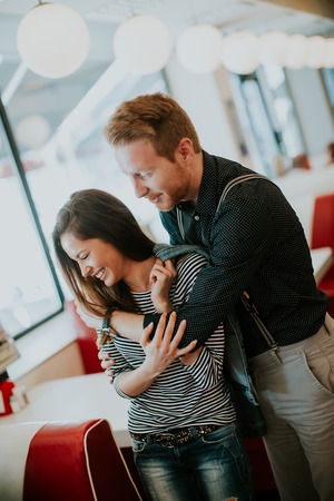 Hugged young couple standing in diner
