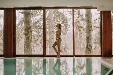 Pretty young woman walking by the swimming poolの写真素材