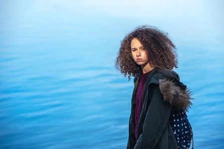 Portrait of curly hair teen girl standing by the riverの写真素材