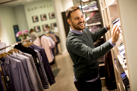 Handsome young man buying clothes in the storeの写真素材