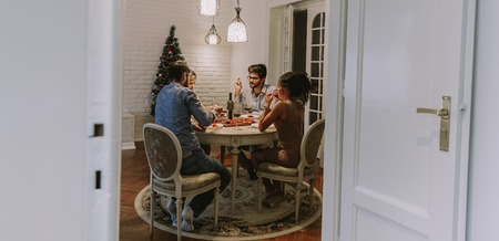 Young friends celebrating Christmas or New Year eve at homeの写真素材