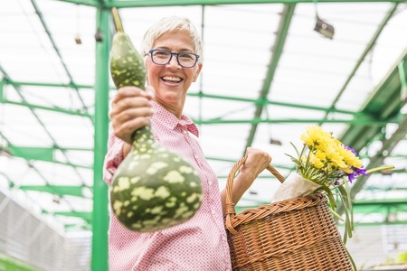 Portrait of senior woman buying gourd on marketの写真素材