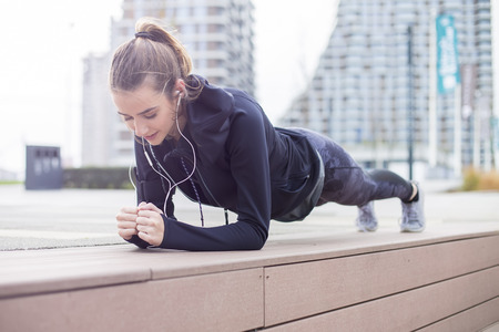 Fit youn woman doing plank exercise outdoor in urban enviromentの写真素材