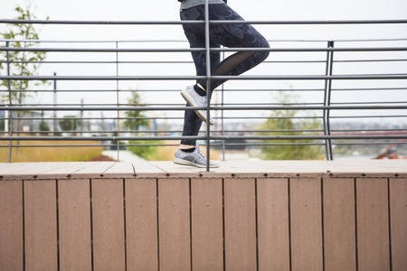 Young sporty woman workout outdoor  by fenceの写真素材