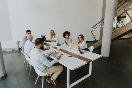 View of multiracial business people around  table during staff meeting and smilingの写真素材