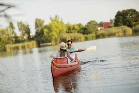 Loving couple rowing on the calm lake at summer dayの写真素材