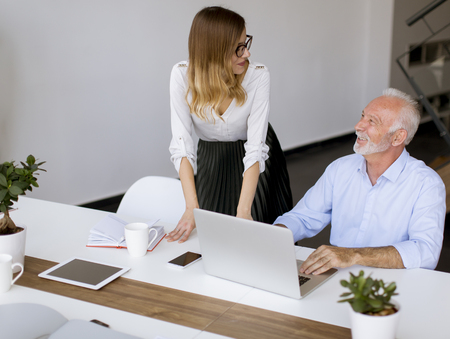 Businesswoman and senior businessman working in officeの写真素材
