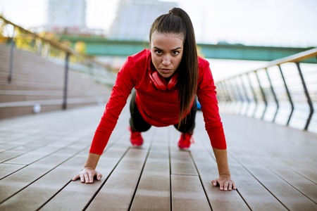 Young woman exercises on the promenade after running in the morningの写真素材