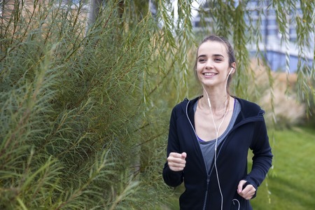 Young fitness woman training and jogging in autumn parkの写真素材