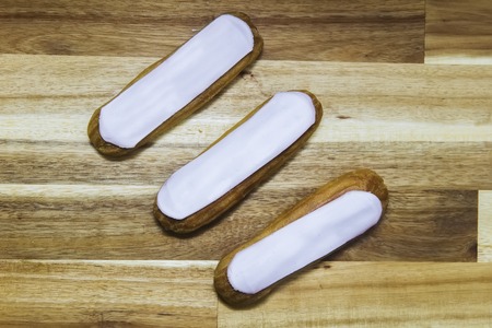 Eclair crispy creamy cake with white chocolate isolated on wooden background