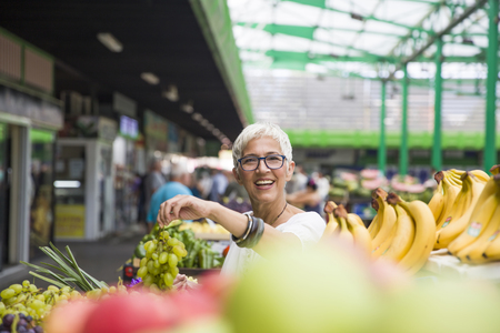 Portrait of senior woman buying fruits on marketの写真素材