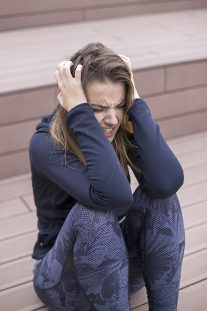 Portrait of angry young woman sitting at outdoorの写真素材