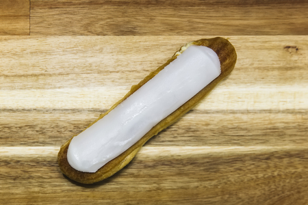 Eclair crispy creamy cake with white chocolate isolated on wooden backgroundの写真素材