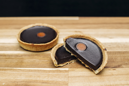 Sweet fresh dark chocolate tart on the wooden tableの写真素材