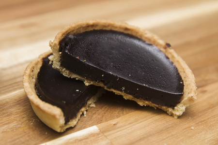 Sweet fresh dark chocolate tart on the wooden tableの写真素材