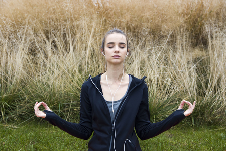 Young woman doing yoga in morning parkの写真素材