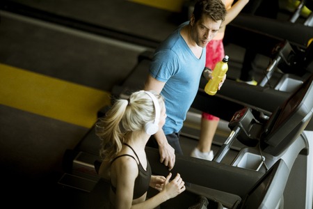 Top view at group of young people running on treadmills in modern gym