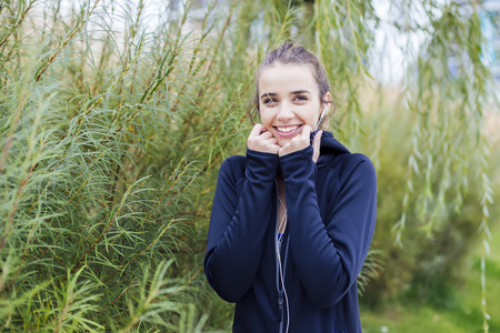 Portrait of sporty and active woman runner is listening to musicの写真素材