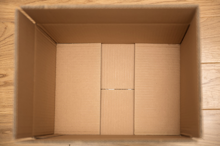 Top view at open cardboard box on the floor in empty room, ready for transportの写真素材