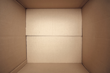 Top view at open cardboard box on the floor in empty room, ready for transport