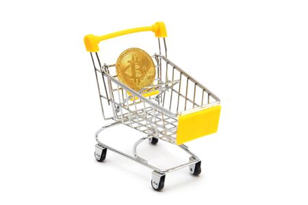 Mini yellow shopping cart with bitcoin isolated on the white backgroundの写真素材