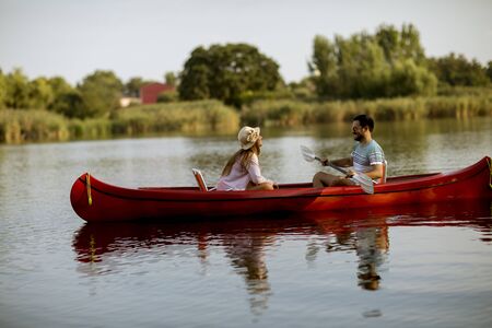 Loving couple rowing on the lake at summer day