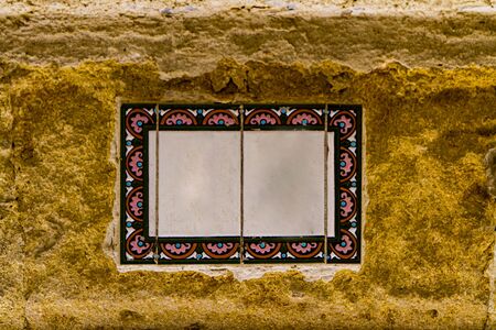 Traditional decorative street number plate from facade of old house in Nimes, France