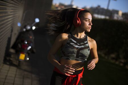 Young slim woman jogging in the sunset