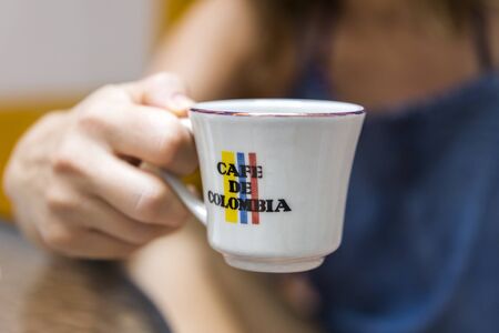 CARTAGENA, COLOMBIA - SEPTEMBER 13, 2019: Woman with Cafe de Colombia cup at Cartagena, Colombia....