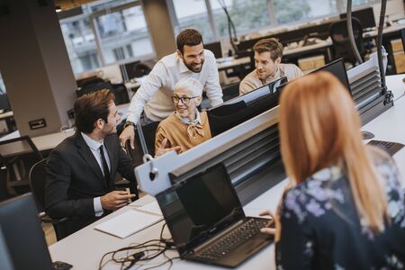 Senior businesswoman working together with young business people in modern office