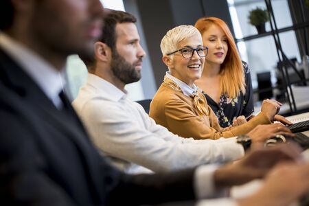 View of businessman executive in group meeting with other businessmen and businesswomen in modern...