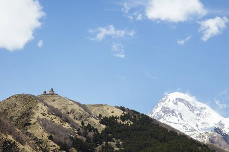 Distant view at famous Gergeti Trinity Tsminda Sameba church in Georgia