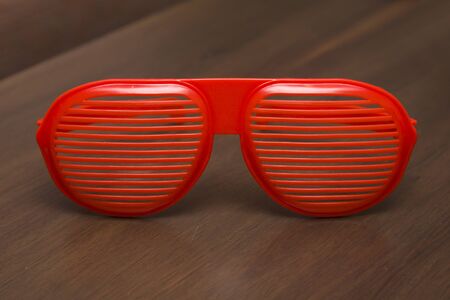 Red shutter shading glasses on the wooden table