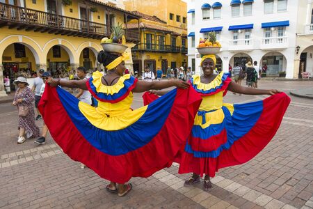 CARTAGENA, COLOMBIA - SEPTEMBER 16, 2019: Unidentified palenquera, fruit seller lady on the street of Cartagena, Colombia. These Afro-Colombian women come from village San Basilio de Palenque, just outside the city.