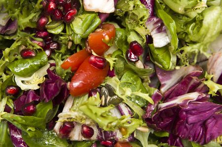 Closeup detail of salad bowl with fresh vegetables backdropの写真素材
