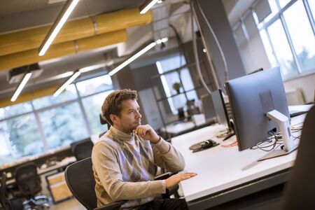 Young professional businessman uses a laptop for work in the modern office