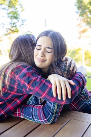 View at two sad best female friends embracing each otherの写真素材