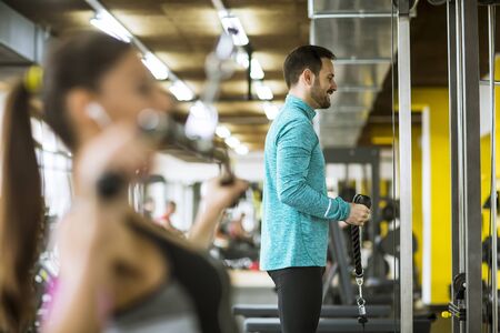 Handsome young couple exercise bodybuilding exercises in the modern gymの写真素材