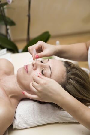 Closeup of cup applied to facial skin of a female patient as part of the traditional method of cupping therapyの写真素材